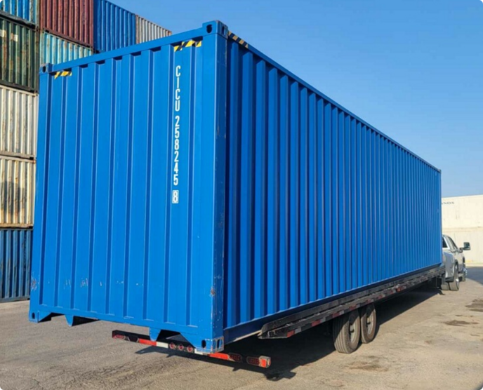 Shipping container being delivered by Box Hub on a tilt-bed trailer